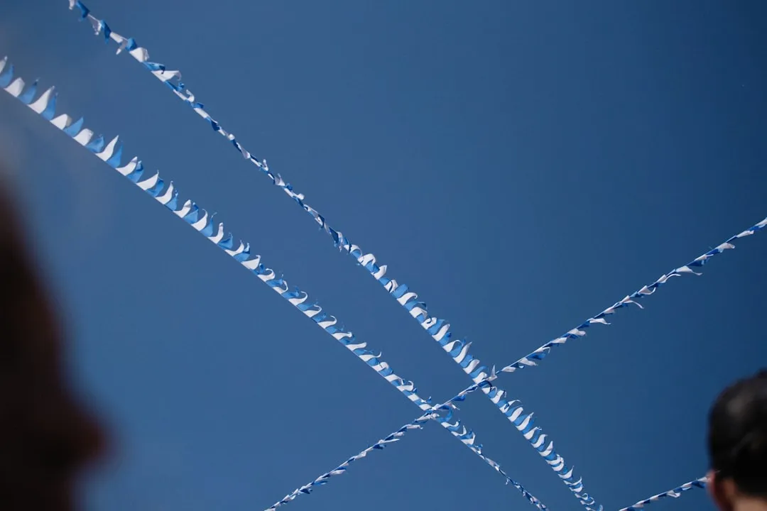a man looking up at a kite flying in the sky