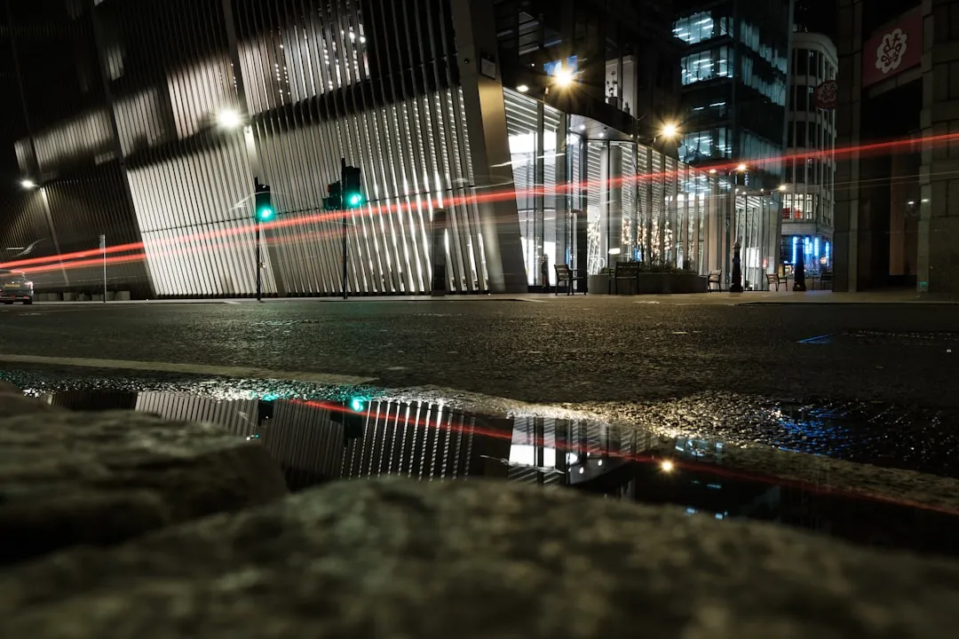 a city street at night with a puddle of water
