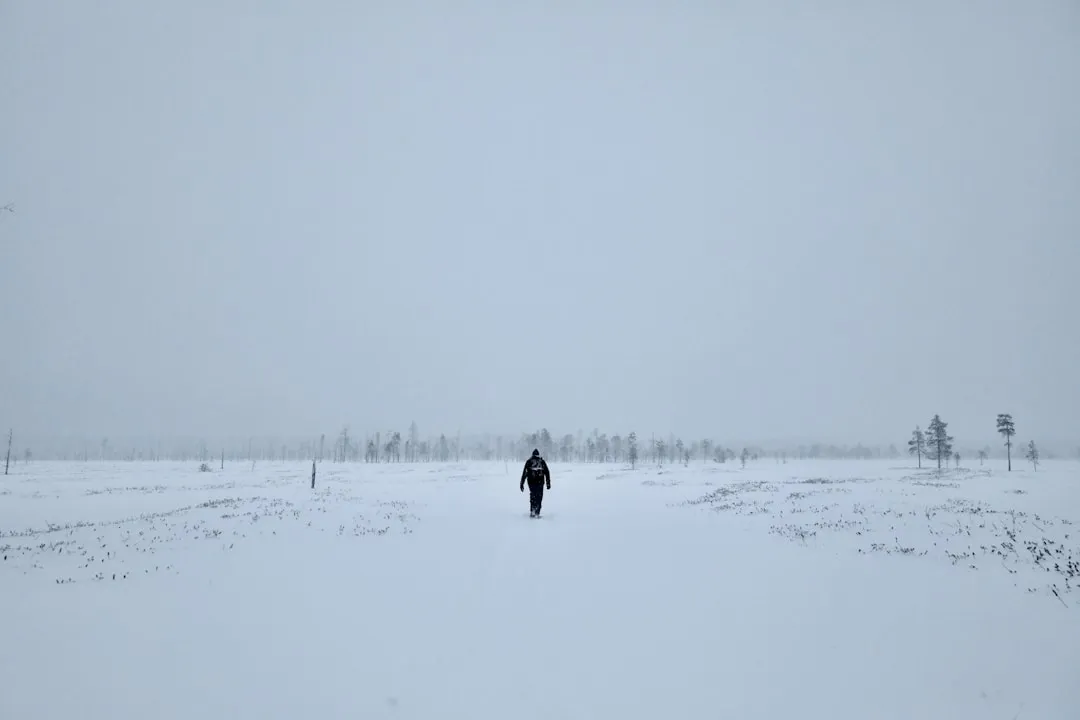 A person walking through a snow covered field