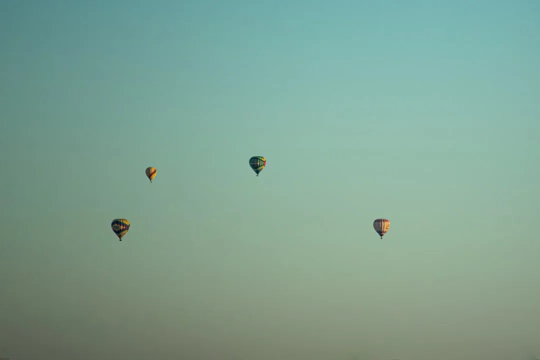 a group of hot air balloons flying in the sky