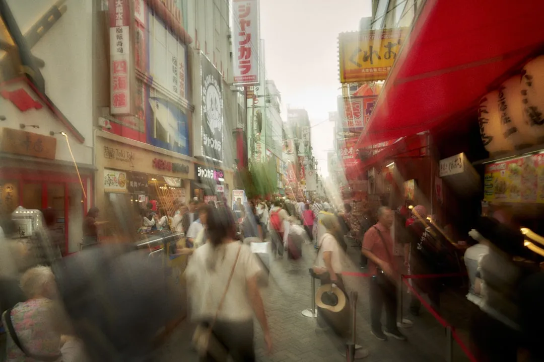 Blurred street scene with crowds and signs