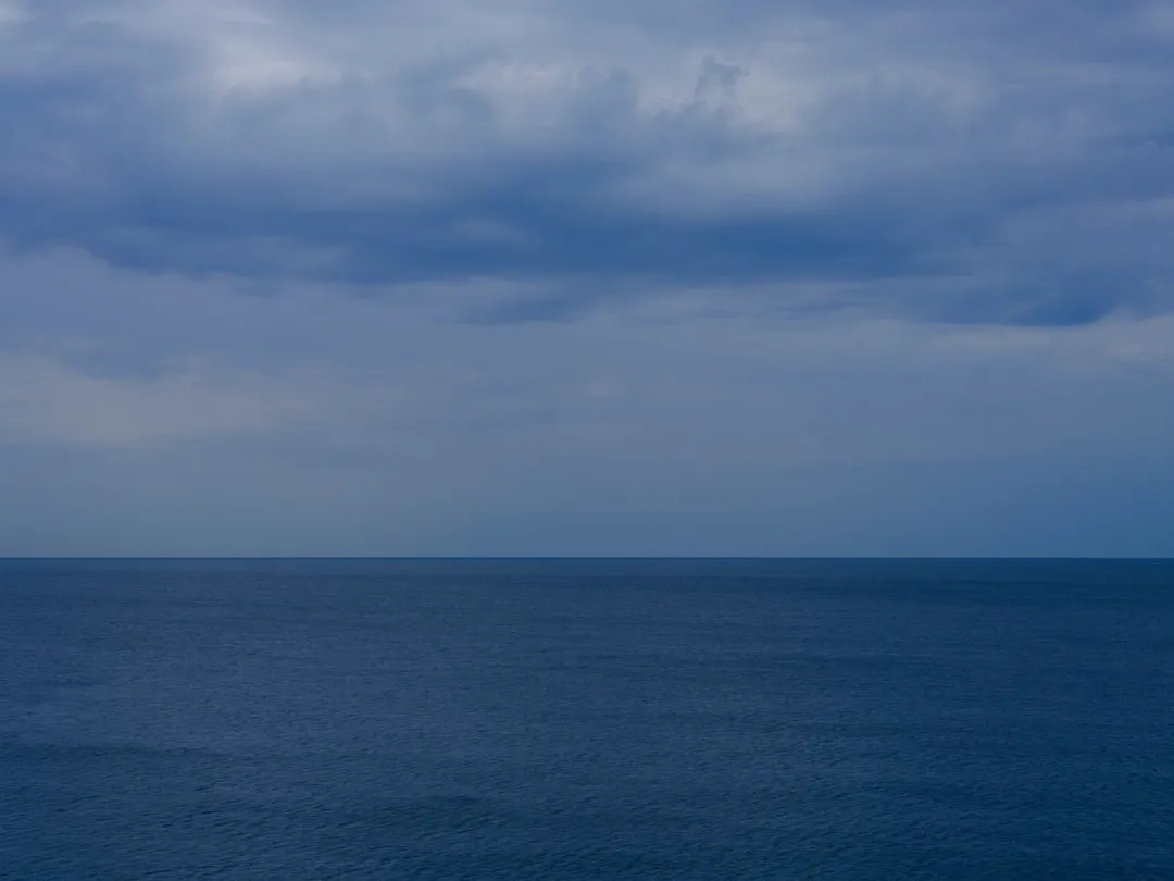 a body of water with clouds above it