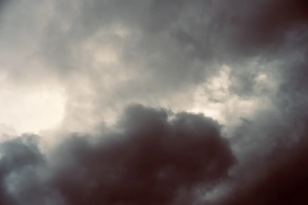 Dark, moody storm clouds with bright sky breaks.
