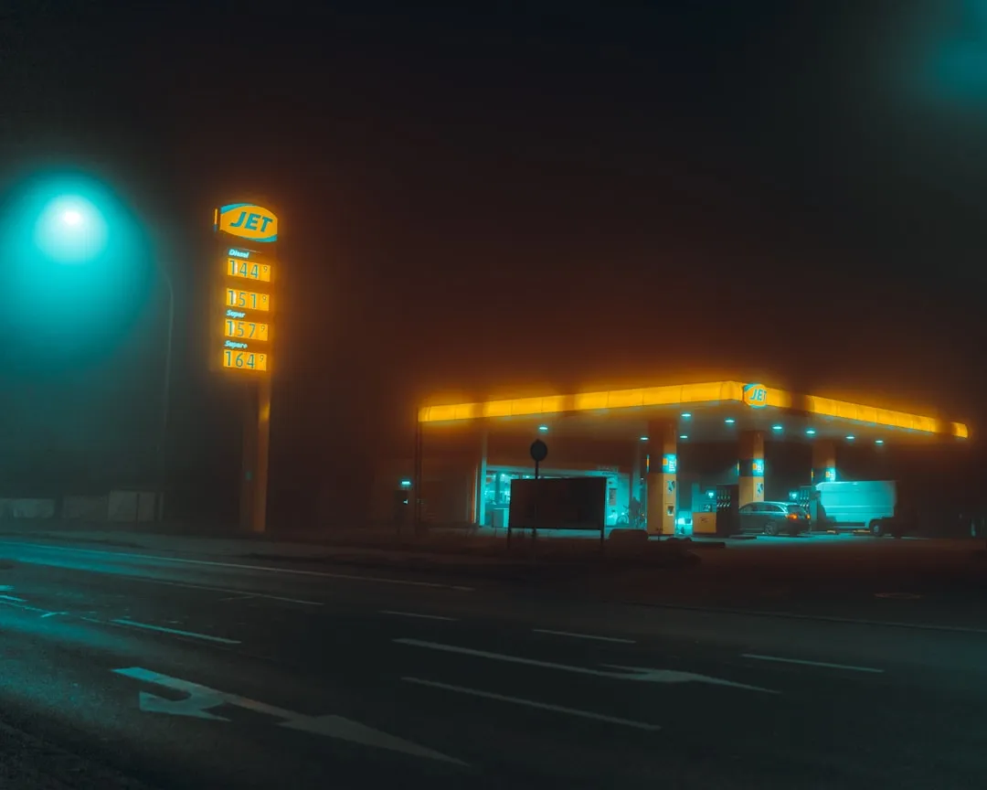 a gas station lit up at night on a foggy night