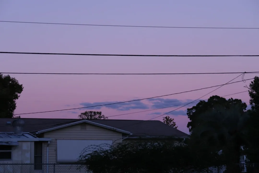 A pink sky is above a house.