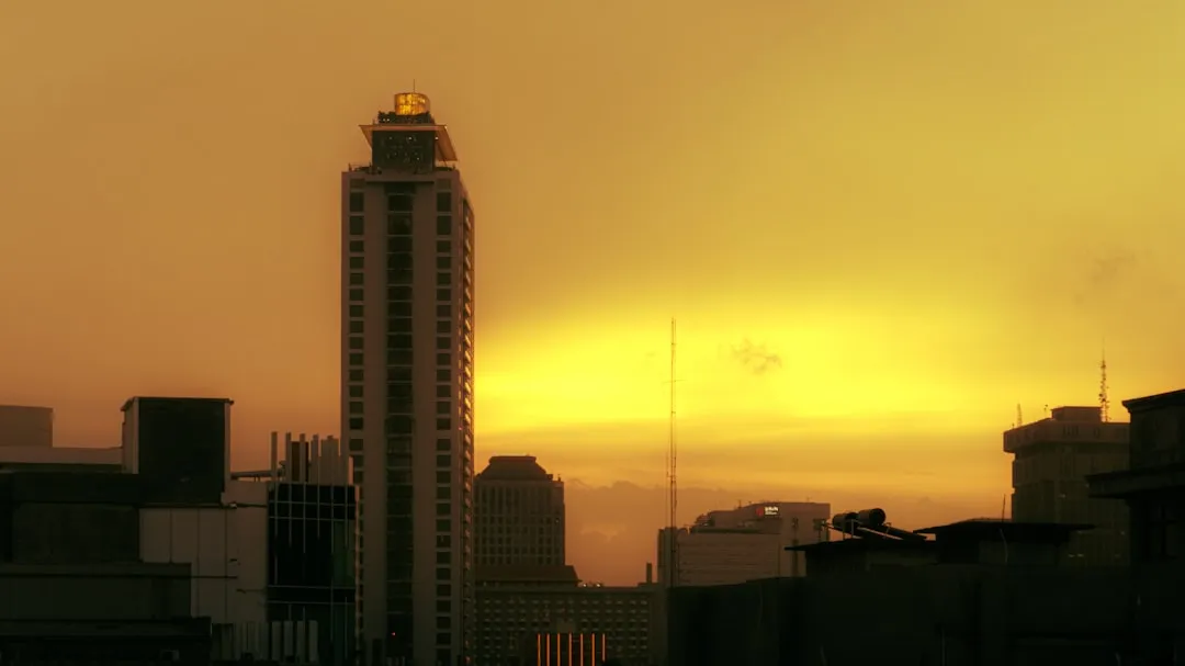 The sun is setting over a city with tall buildings
