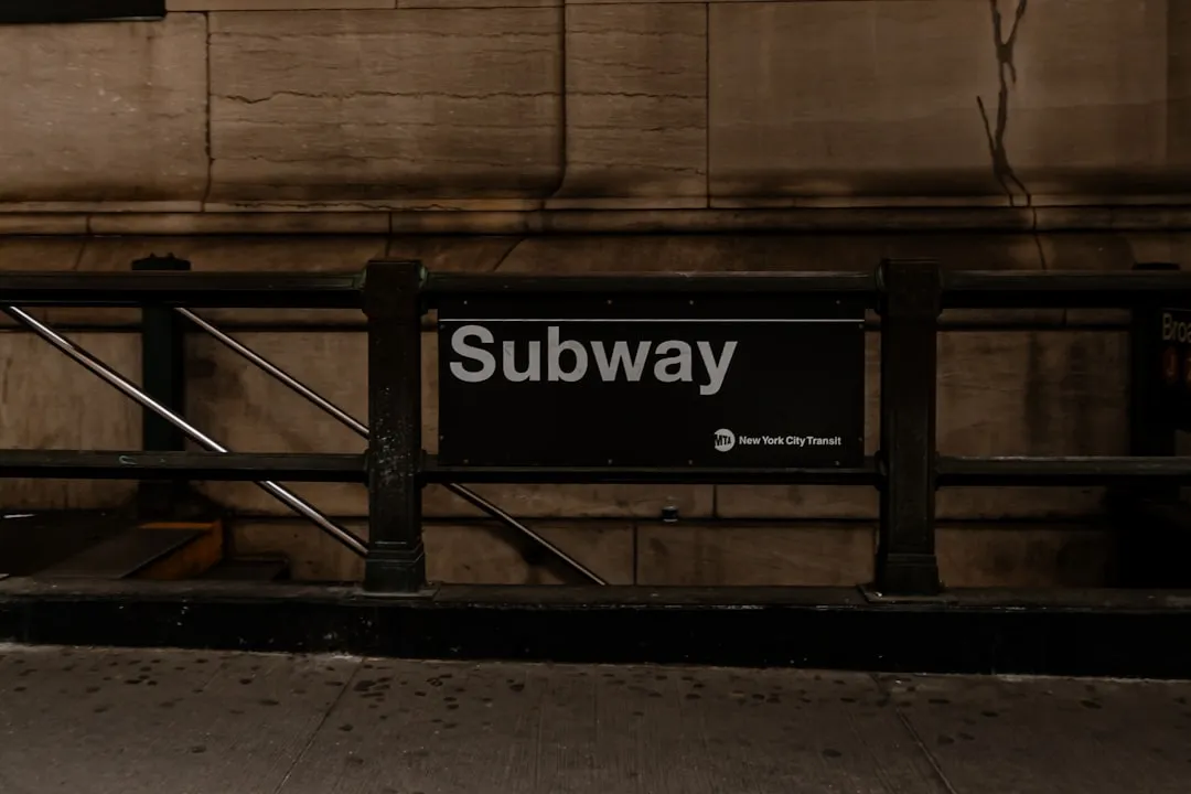 a subway sign sitting on the side of a building