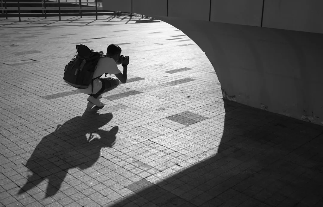 grayscale photography of person holding camera