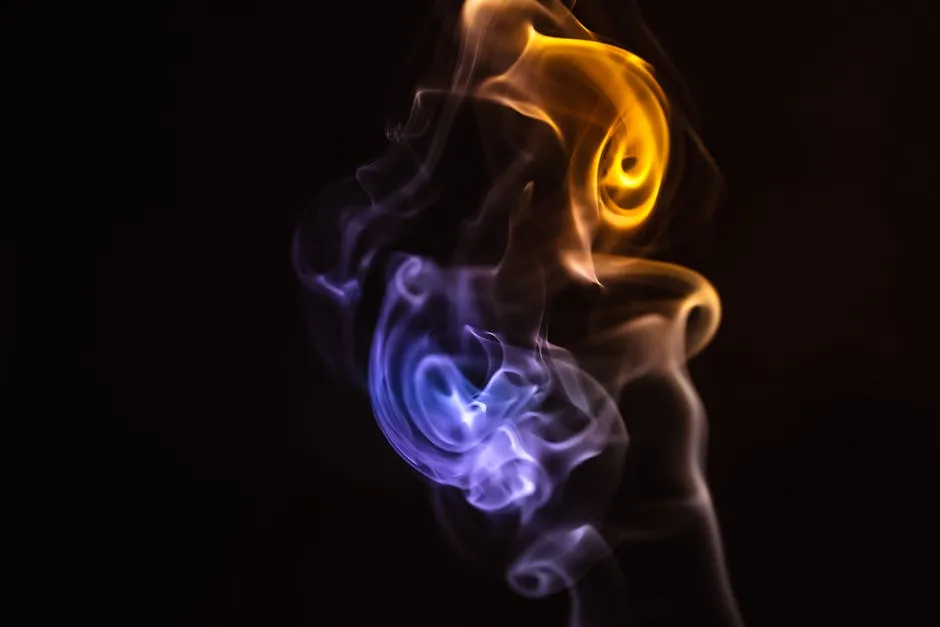 Mesmerizing photograph of orange and blue smoke twists against a black backdrop.