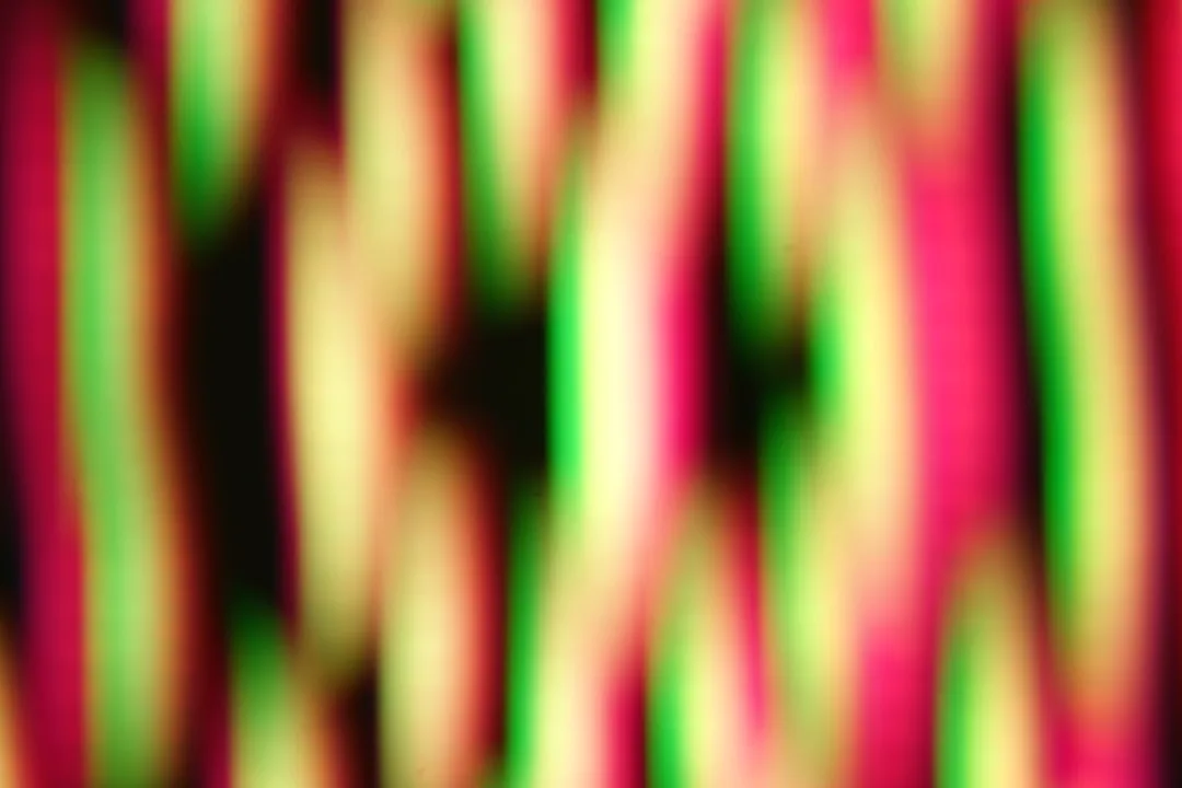 Abstract vertical stripes of red, green, and yellow light.