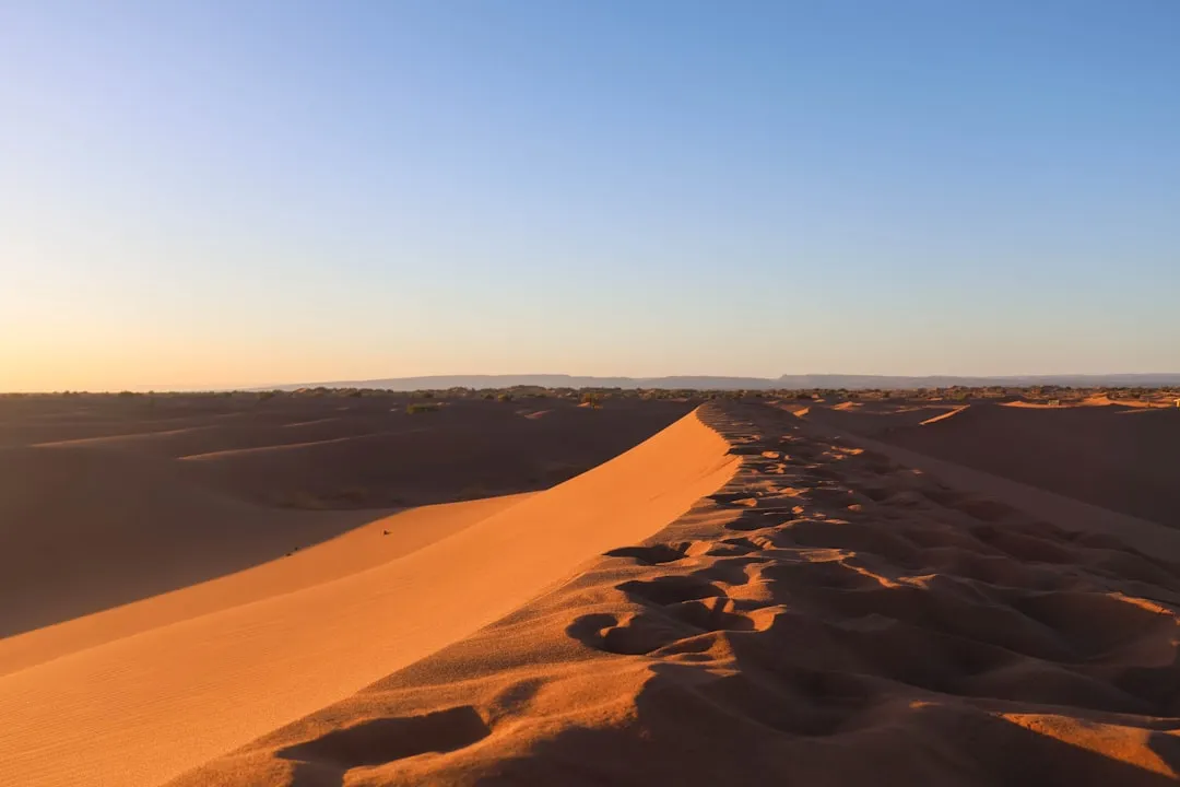 Golden sand dunes under a clear blue sky